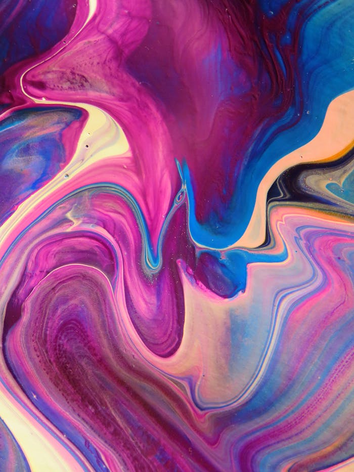 A dynamic abstract artwork featuring swirling patterns in vivid pink, blue, and purple hues.